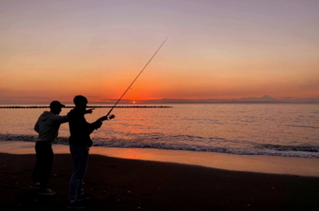 海岸では釣り人が釣り糸を海に投げ入れてい