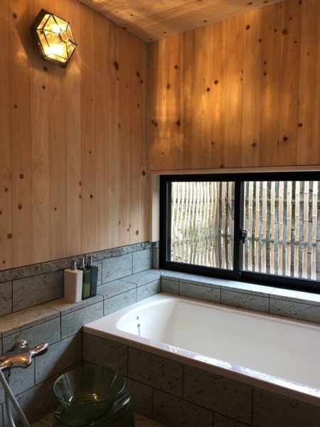 十和田石、檜板張り、坪庭付の浴室。