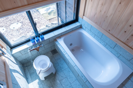 檜の板、十和田石張りの浴室